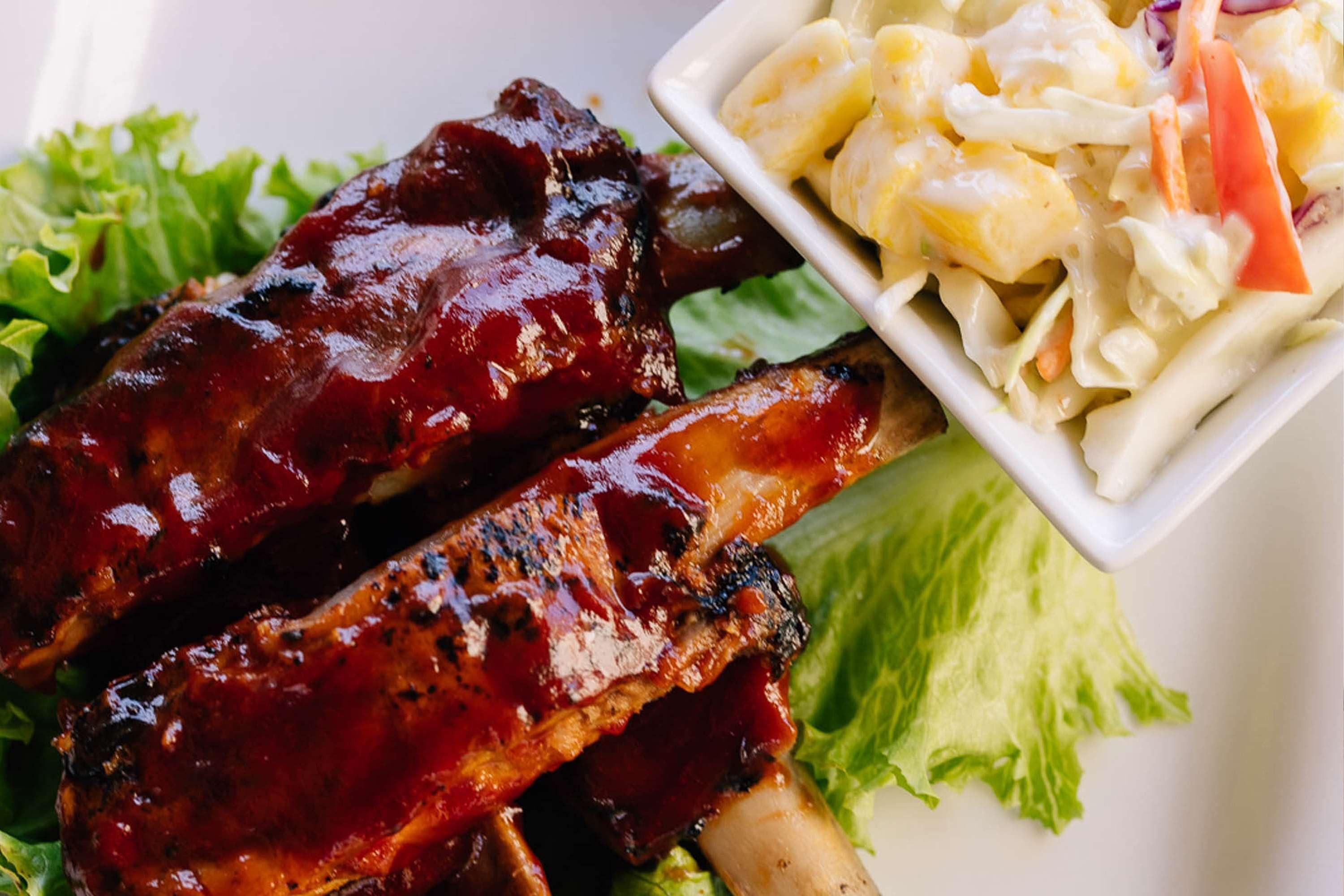 Een bord met barbecueribs en een salade.