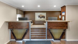 A reception desk with a mounted artwork of a bison, a wooden counter, and a framed certificate on the wall. - SureStay by Best Western Lakeview (Lakeview)
