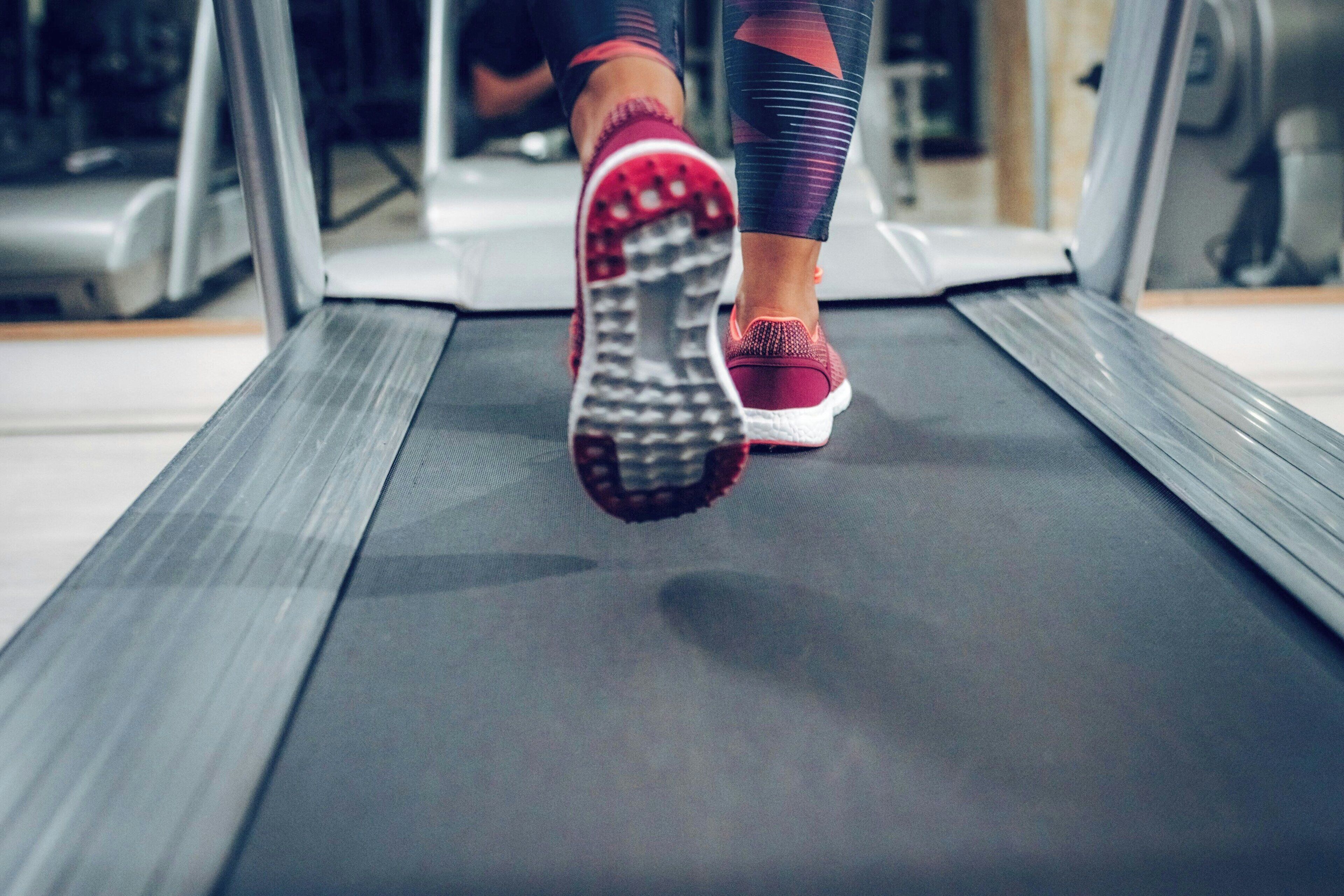 Esteira numa academia com uma pessoa a correr.
