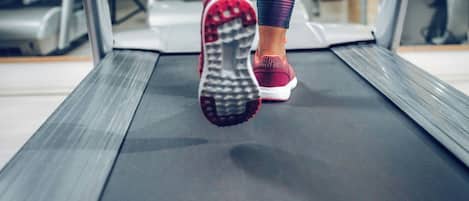 Esteira numa academia com uma pessoa a correr.