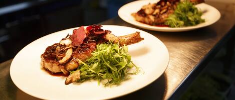 Two plates of food on a stainless steel counter.