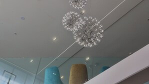 A modern interior with geometric light fixtures and a glass railing. - Copthorne Hotel Palmerston North (Palmerston North)
