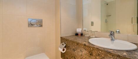 A bathroom with a toilet, sink, mirror, and towel.