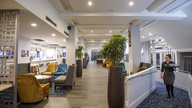 A hotel lobby with seating areas, a reception desk, and a large potted plant. - Copthorne Hotel Palmerston North (Palmerston North)