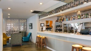 A bar area with stools, a counter with bottles, and a decorative partition. - Copthorne Hotel Palmerston North (Palmerston North)