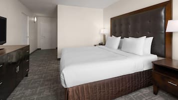 A hotel room with a bed, a TV, a desk, and a wardrobe.
