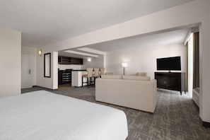 A hotel room with a large bed, a sofa, a TV, a desk, and a kitchenette. - Wyndham Sacramento (Sacramento)