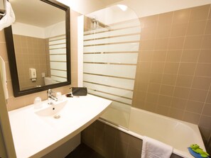 Een bad,  milieuvriendelijk toiletgerief, een haardroger, handdoeken