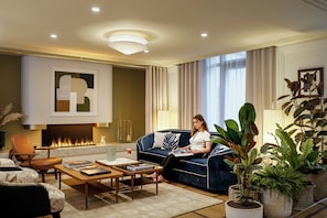 A modern living room with a sofa, coffee table, and a fireplace. - Hotel Faubourg Galant Paris - Handwritten Collection (Paris)