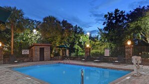 A swimming pool with a brick border, surrounded by lounge chairs and a covered seating area. - Hampton Inn Charleston/Mount Pleasant-Patriots Point (Mount Pleasant)