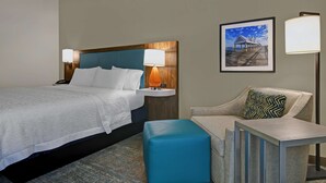 A hotel room with a bed, a nightstand, a desk, a chair, and a picture on the wall. - Hampton Inn Charleston/Mount Pleasant-Patriots Point (Mount Pleasant)