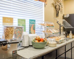 A buffet setup with labeled sections for 'hot', 'fresh', and 'healthy' foods, including cereals, fruits, and bread. - Quality Inn Broken Arrow - Tulsa (Broken Arrow)