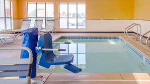 En swimmingpool med solstolar och en livräddarstol.