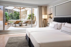 A hotel room with a large bed, a balcony with a sun lounger, and a view of the cityscape. - Melia Sevilla (Seville)