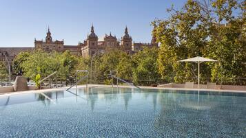 Een buitenzwembad, parasols voor strand/zwembad