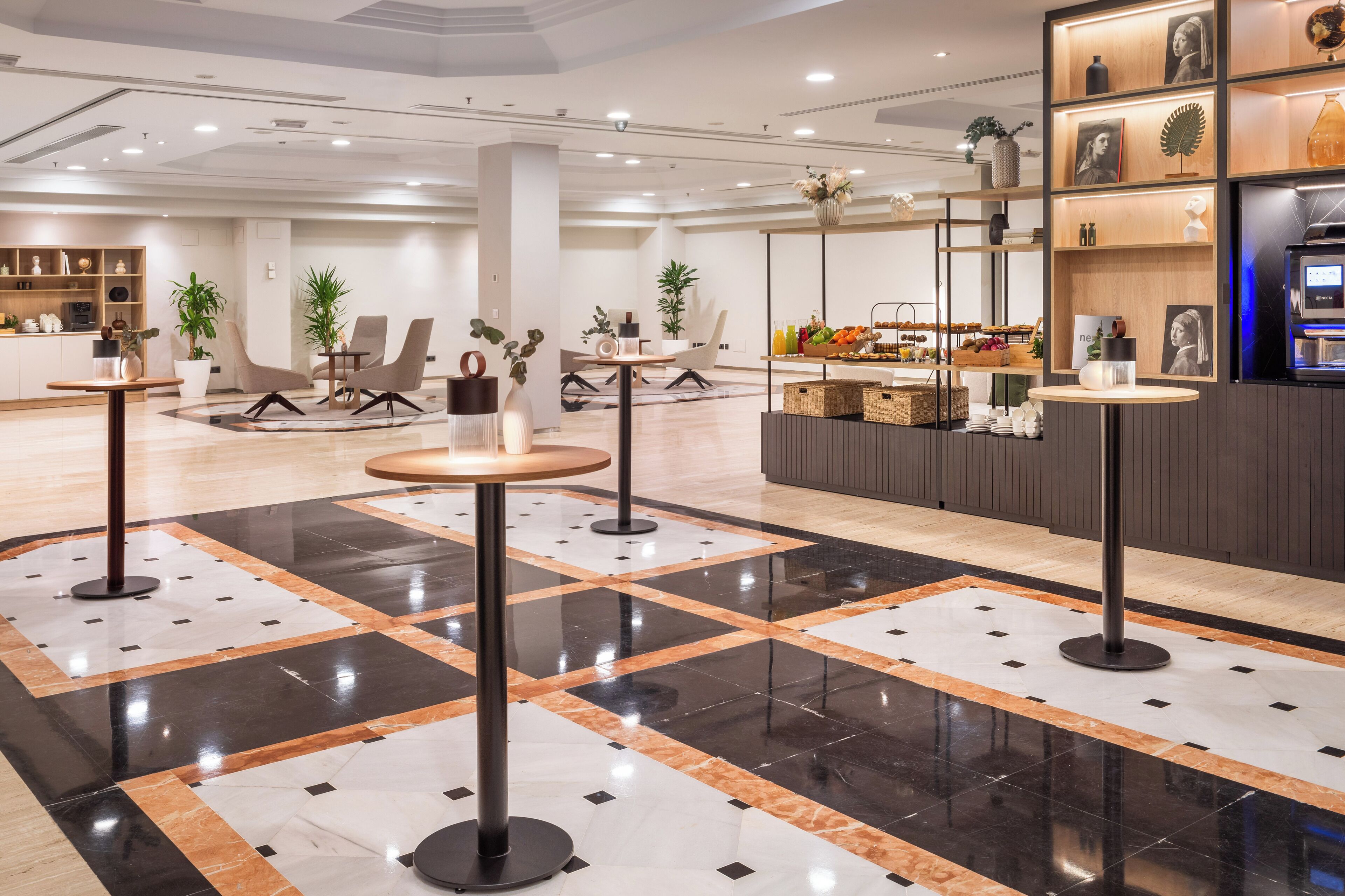 En moderne hotellobby med et centralt siddeområde, en reception og et udstilling af lokale produkter.