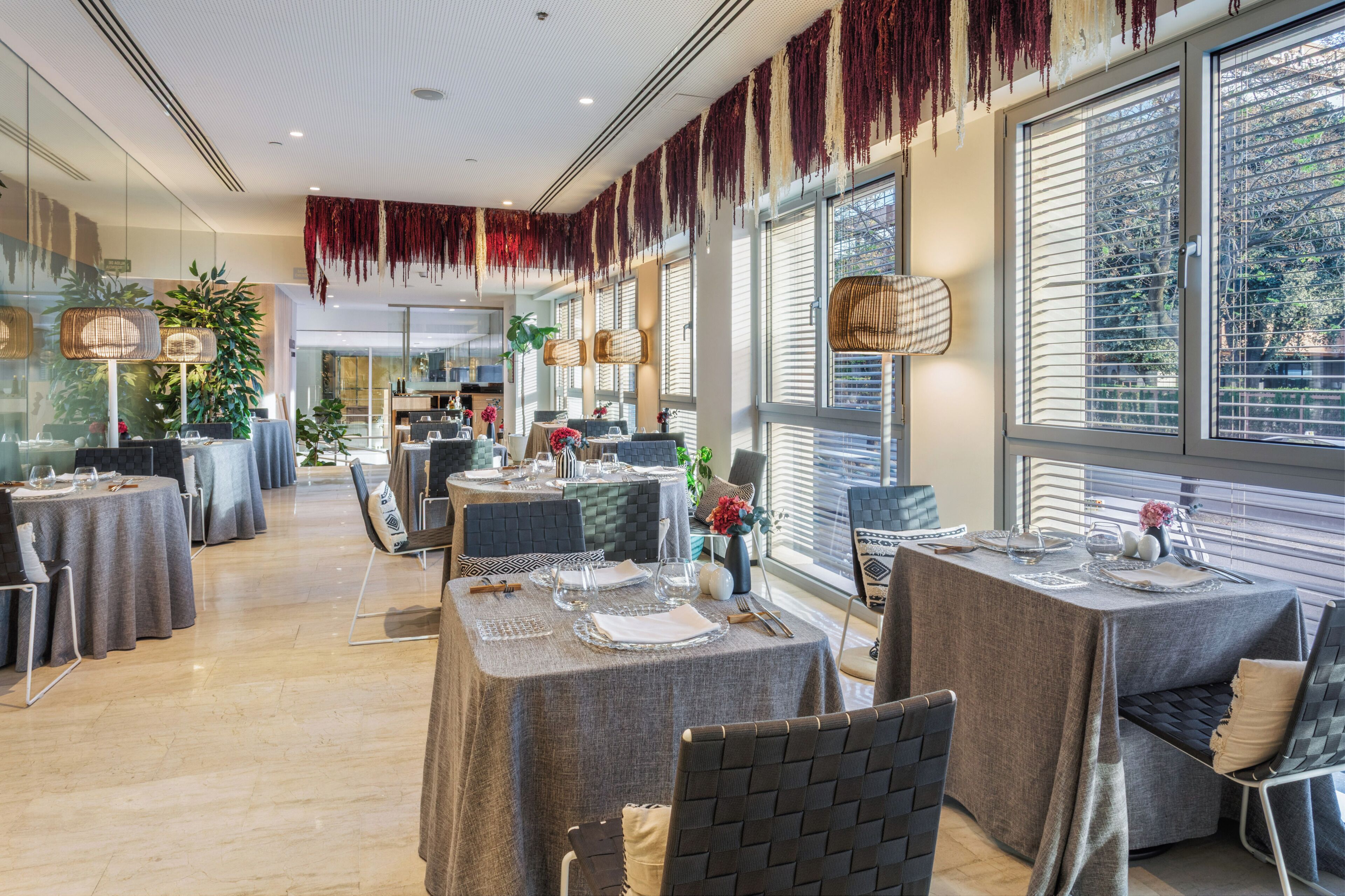 A restaurant with round tables, chairs, and hanging decorations.