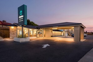 A hotel entrance with a sign for Clarion Pointe by Choice Hotels, a covered parking area, and a clear directional arrow on the ground. - Clarion Pointe Mount Vernon - Burlington (Mount Vernon)