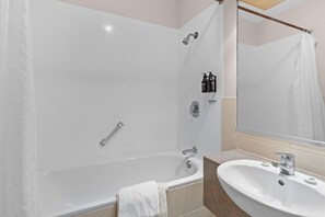 Ein modernes Badezimmer mit Badewanne, Waschbecken und Dusche.