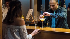 A bar setting with a bartender preparing a drink. - Copthorne Hotel Rotorua (Rotorua)