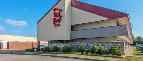A Red Roof Inn with a modern architectural design, featuring a prominent red roof and a stone facade.