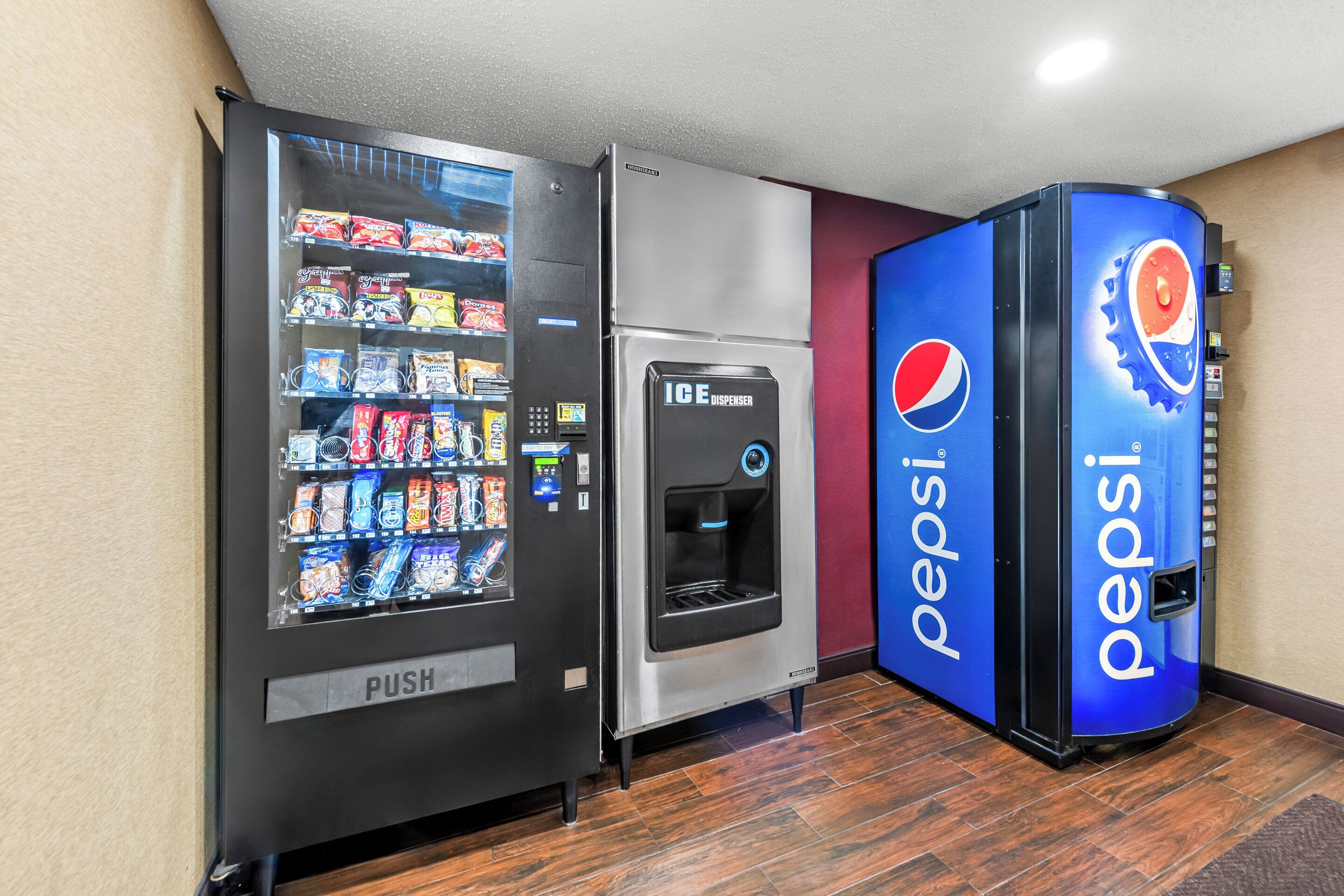 Zona de máquinas expendedoras con dispensador de Pepsi y una máquina expendedora de tipo push.