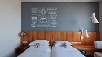 Une chambre d’hôtel avec deux lits, une tête de lit en bois, une œuvre d’art murale, une lampe de chevet et une table de chevet avec une lampe.