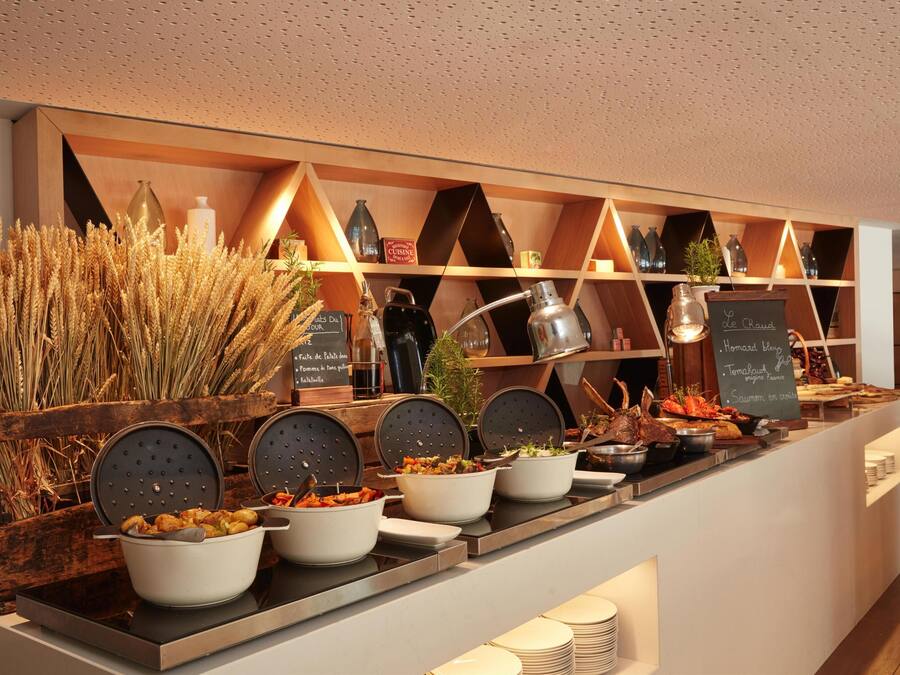 Un buffet con diversi piatti e una parete decorativa con mensole.
