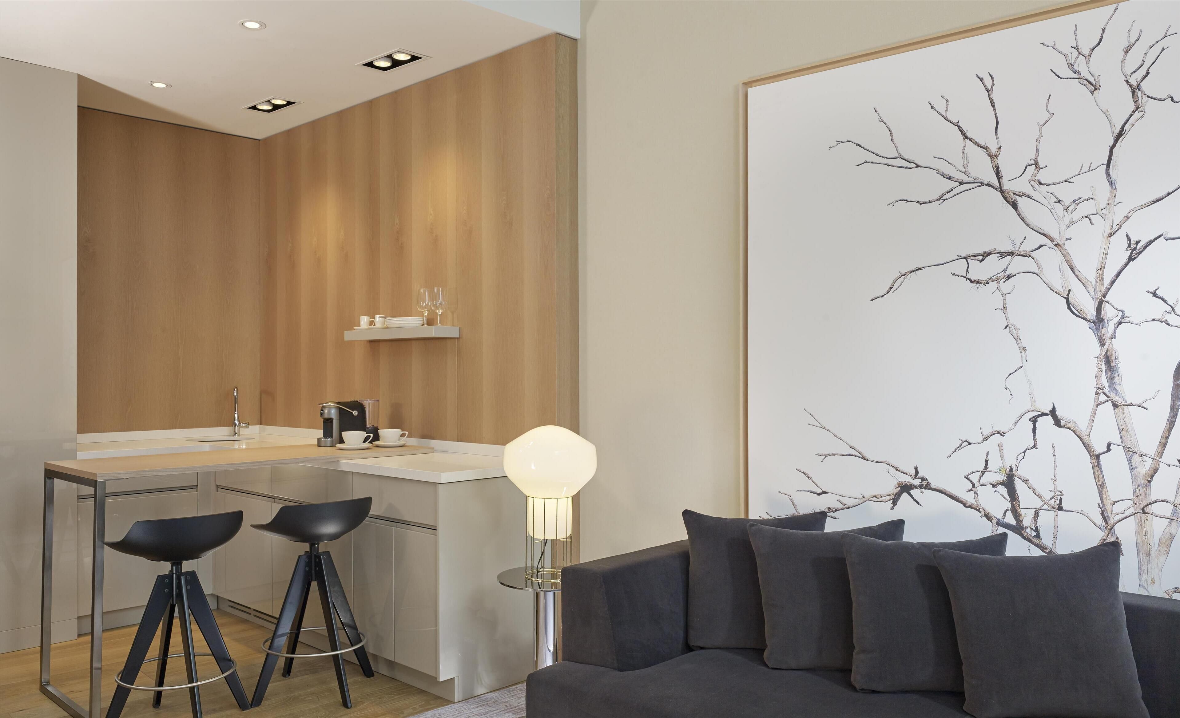 A modern kitchen with a wooden accent wall, a bar area, and a dining setup.