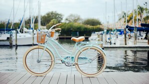 A vintage bicycle with a basket and seat, docked on a wooden pier with boats in the background. - Holiday Inn Express Hilton Head Island by IHG (Hilton Head Island)