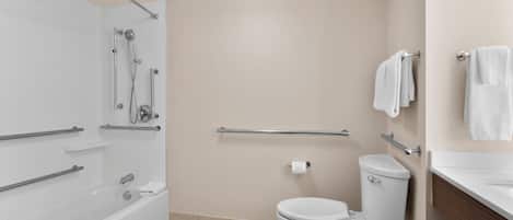 A modern bathroom with a bathtub, toilet, and shower.