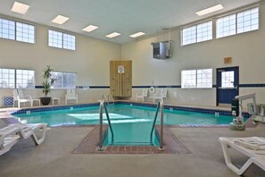 Una piscina techada, sillones reclinables de piscina
