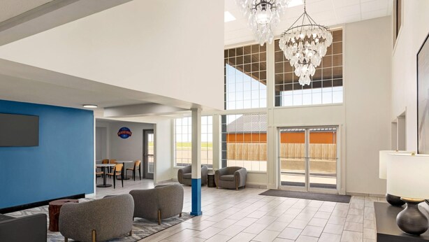 A spacious lobby with a high ceiling, a chandelier, and a large window.