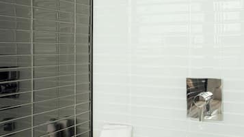 A bathroom with a bathtub, a window with blinds, and toiletries on the counter.