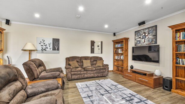 A living room with a sofa, a TV, and a bookshelf. - Southgate Motel (Mount Gambier)