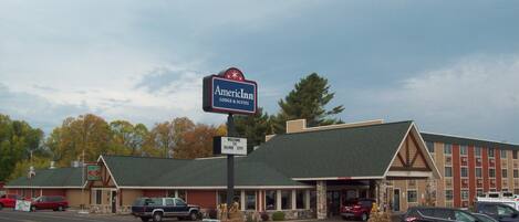 Un motel con un letrero de AmericInn, un cartel de bienvenida a Silver City y un restaurante visible llamado Porky's.