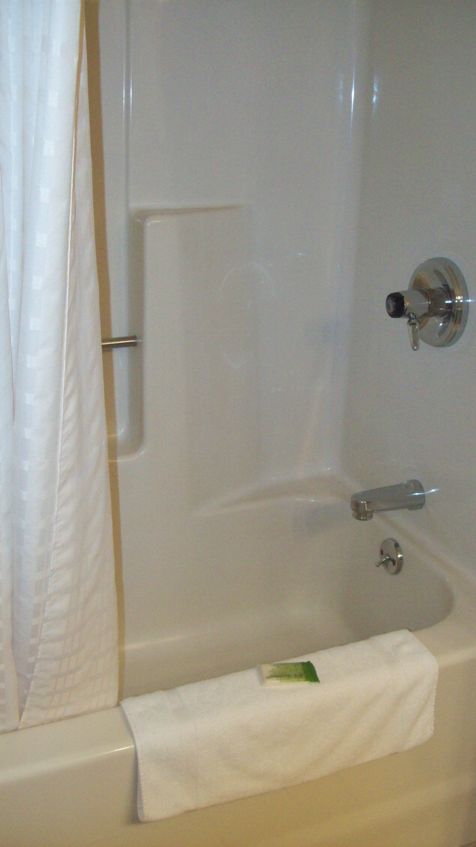 A standard white bathtub with a faucet and a shower curtain.