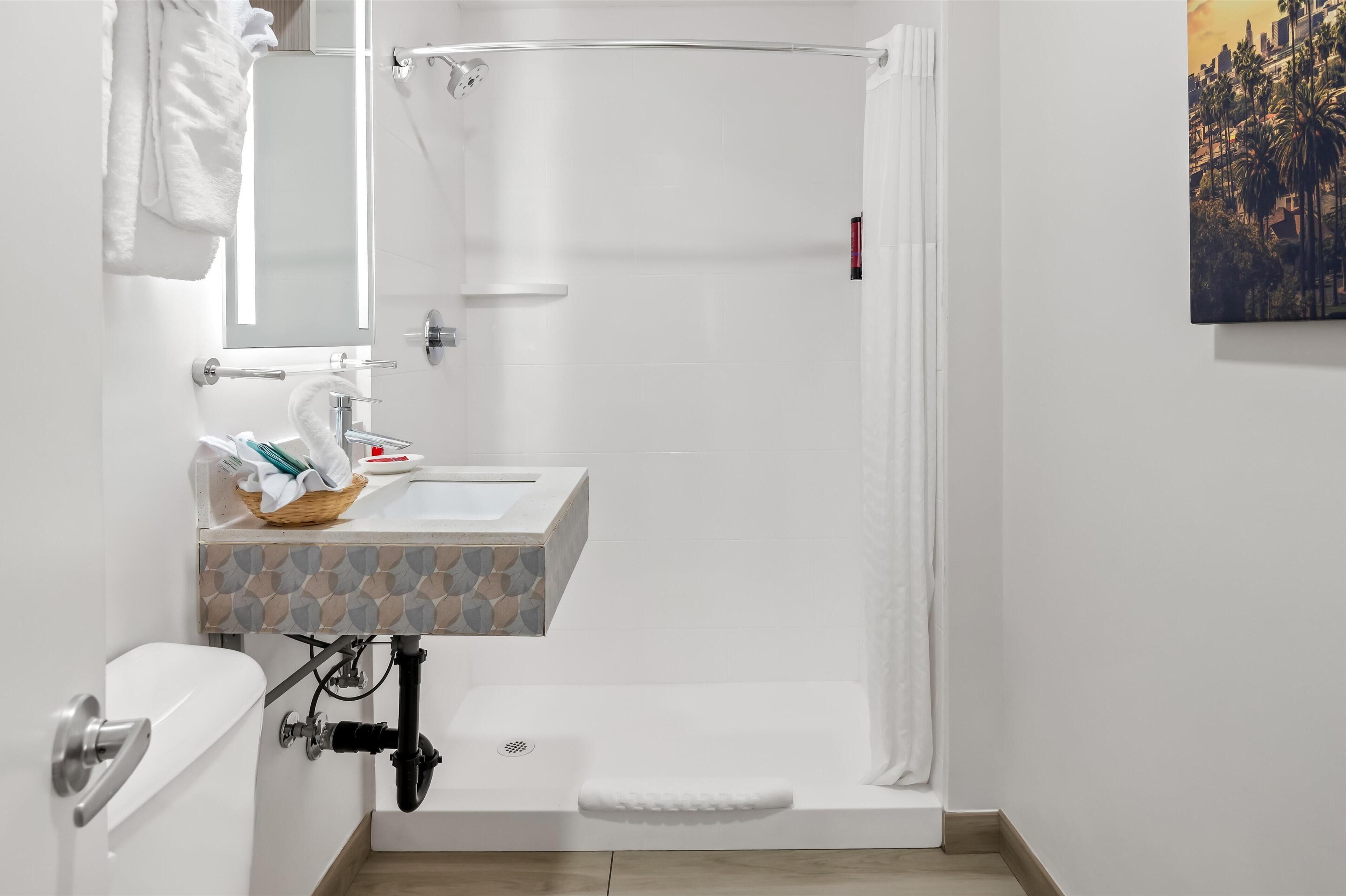 A bathroom with a shower, toilet, and sink.