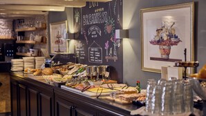 Un buffet de petit-déjeuner proposant une variété d’aliments et un menu écrit à la craie.