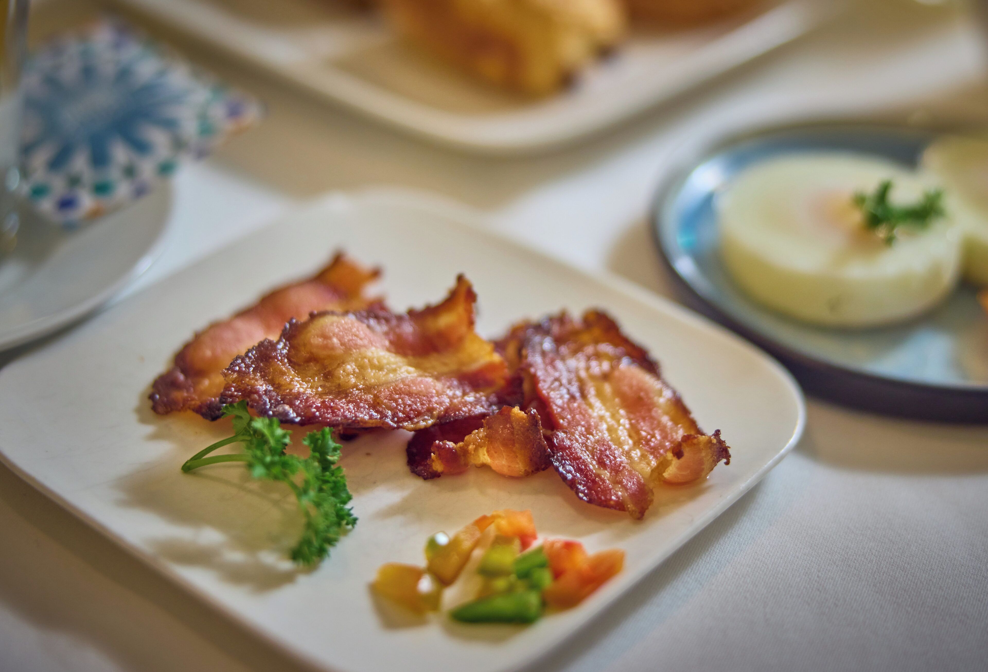 A plate with bacon and vegetables.
