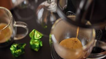 A coffee machine dispensing coffee into a glass cup.