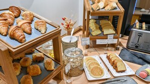 A breakfast buffet with croissants, bread, and pastries. - Hôtel Elysées Opéra (Paris)
