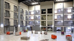 A spacious indoor area with multiple levels of balconies, seating areas, and a central open space.