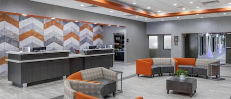 A modern reception area with a check-in counter, seating area, and a patterned wall.