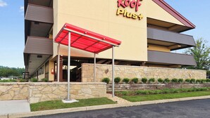 Un hôtel Red Roof Inn avec une structure à deux étages, une entrée couverte et une façade en pierre.