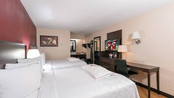 A hotel room with two beds, a desk, a chair, a television, and a mirror.