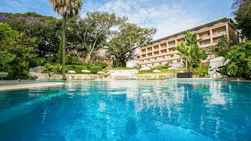 Una piscina techada, una piscina al aire libre de temporada, sombrillas