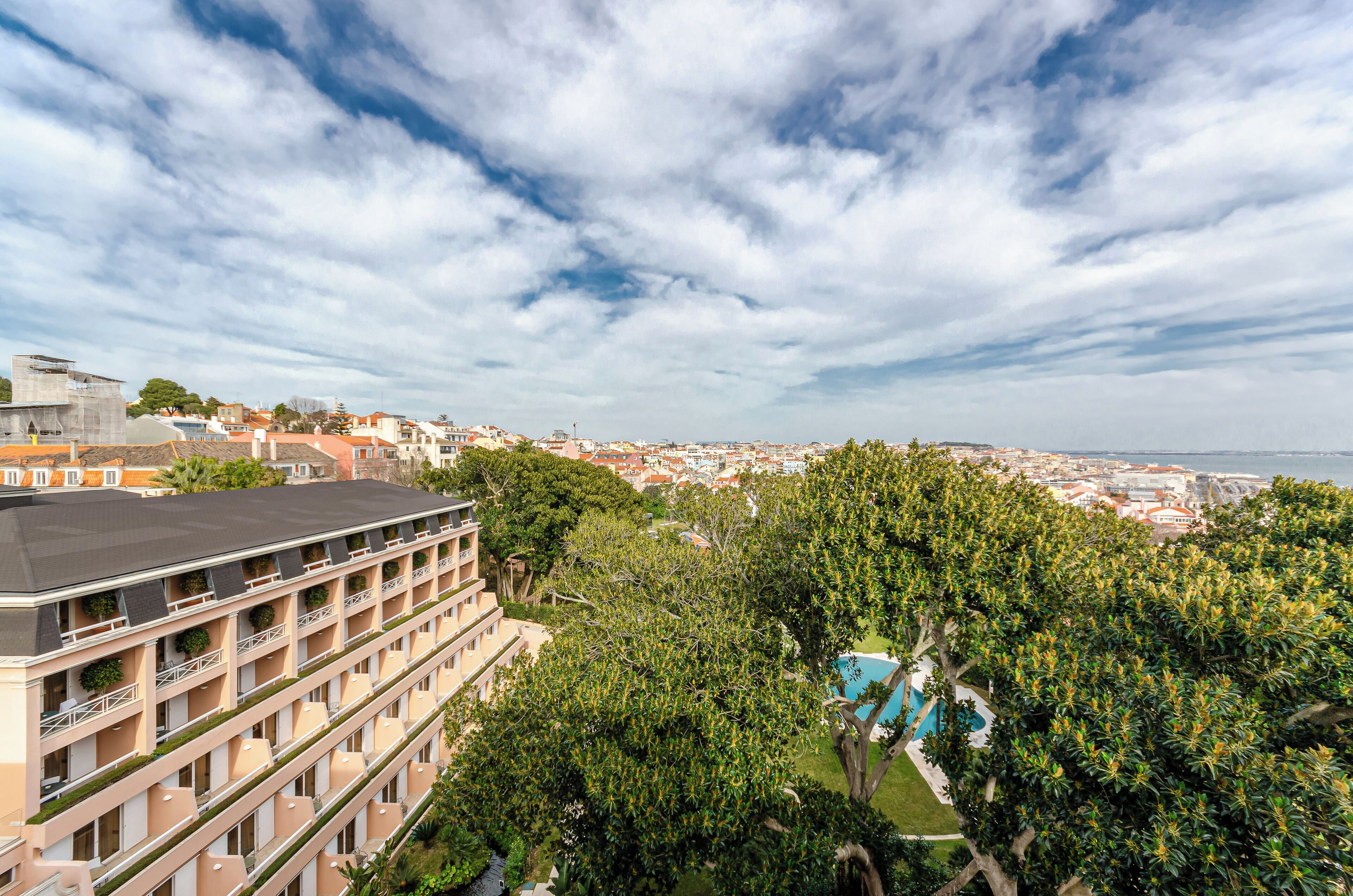 Un hôtel à étages, doté d’une piscine et offrant une vue sur la ville et la mer.