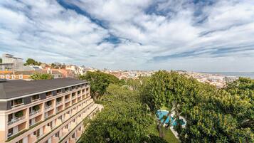 Un hôtel à étages, doté d’une piscine et offrant une vue sur la ville et la mer.
