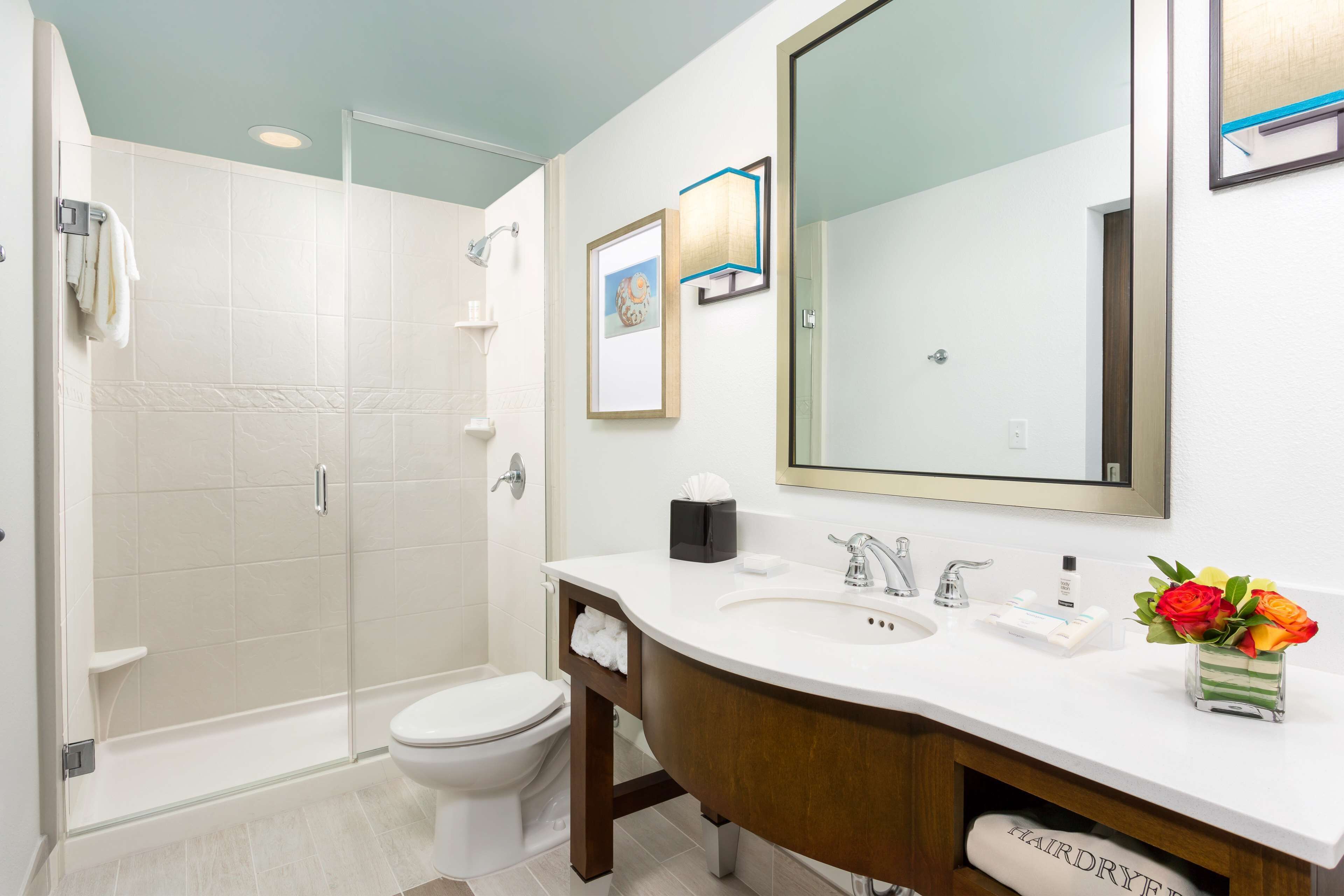 A modern bathroom with a shower, toilet, and vanity.